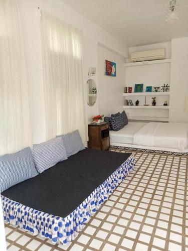 a bedroom with a large bed and a couch at Brassiere Beach Hotel in Baanphakrimlay 