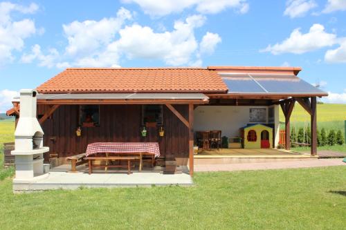 a house with a picnic table and a play house at Penzion Úsmev in Arnutovce