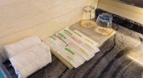 a shelf with towels and baskets on a counter at The Prosperous City Hotel Weifang in Weifang