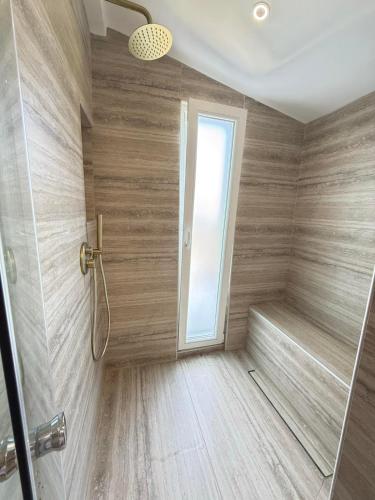 a bathroom with a shower with a wooden floor at Villa Agora Nea Kalikratia in Nea Kalikratia