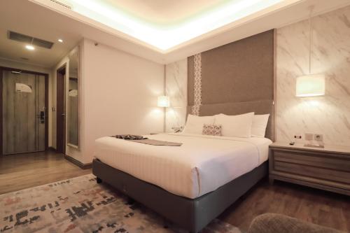 a bedroom with a large white bed in a room at Zigna Kampung Batik in Solo