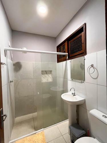 a bathroom with a shower and a toilet and a sink at Apto Exclusivo a 30m da Praça da Sé - Norões Residence in Crato