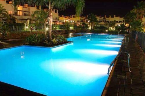 una gran piscina con iluminación azul por la noche en Condado de Alhama N5, en Alhama de Murcia