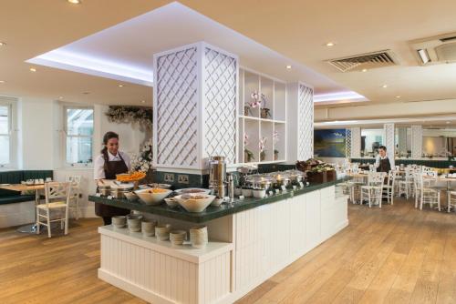 a restaurant with a counter with food on it at Park International Hotel in London