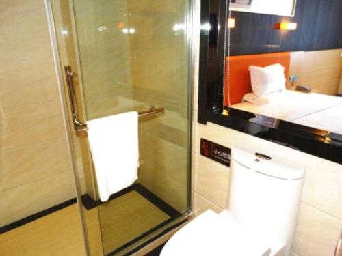 une salle de bain avec WC et cabine de douche en verre dans l'établissement 7 Days Premium Hotel Yangzhou Baoying Time Plaza Maternity and Child Healthcare Hospital, à Huazhuang