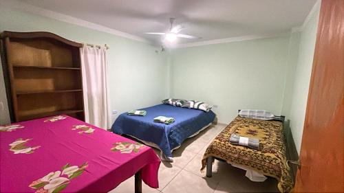 a room with two beds and a table in it at Casita cómoda y de confianza in San Fernando del Valle de Catamarca