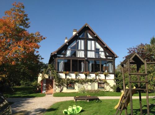 a large house with a bench in front of it at La Maison du Verger in Acquigny
