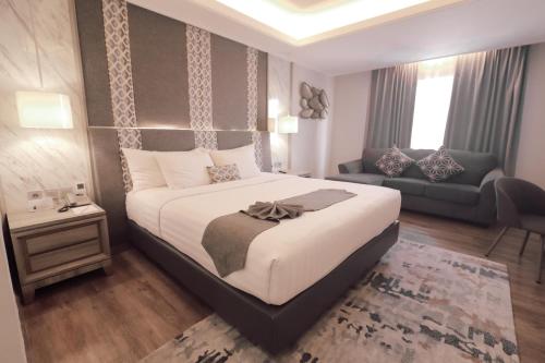 a bedroom with a large bed and a couch at Zigna Kampung Batik in Solo