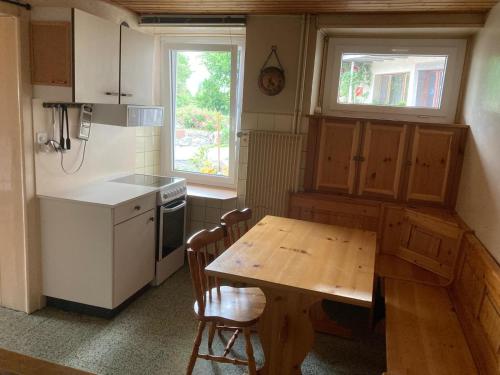 a kitchen with a wooden table and a table and chairs at Gramimmo - Appartement La Cascade in Salvan