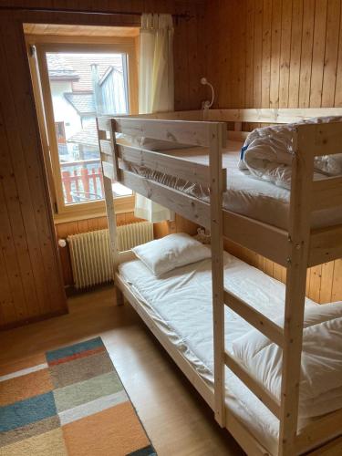 two bunk beds in a room with a window at Gramimmo - Appartement La Cascade in Salvan