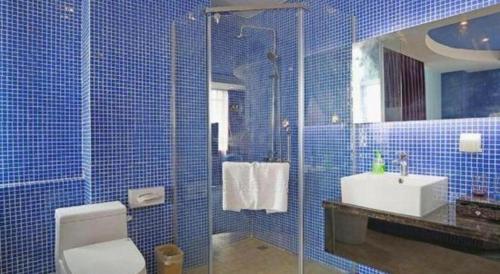 a blue tiled bathroom with a toilet and a sink at TO915101 STILL LOVE THEME HOTEL in Chengdu