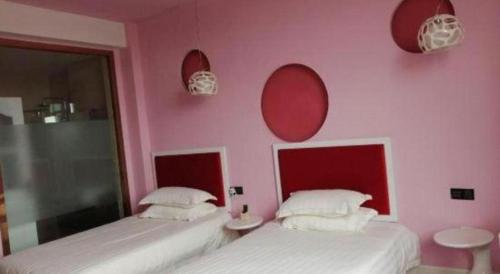 two beds in a room with pink walls and mirrors at TO915101 STILL LOVE THEME HOTEL in Chengdu