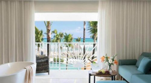 a living room with a blue couch and a view of the ocean at EXCELLENCE PUNTA CANA - ALL INCLUSIVE - ADULTS ONLY in Punta Cana