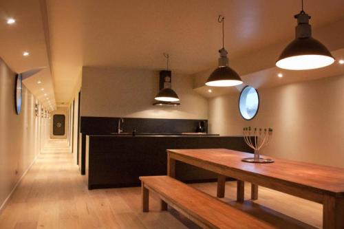 a kitchen with a wooden table and some lights at Bed in Boat in Ypres