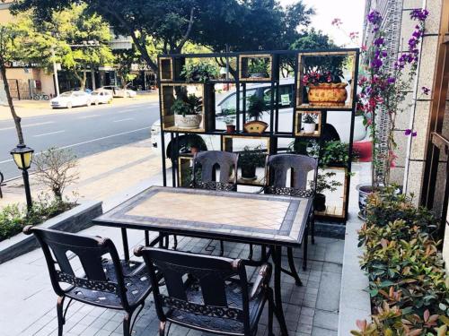 a table and chairs on a patio with plants at James Joyce Coffetel Chengdu Jichang Road Shenxianshu in Chengdu