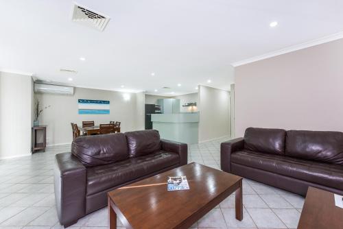 a living room with two leather couches and a coffee table at Mandurah Quay Resort in Mandurah