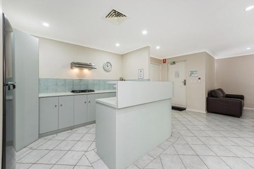 a kitchen with a white counter top in a room at Mandurah Quay Resort in Mandurah