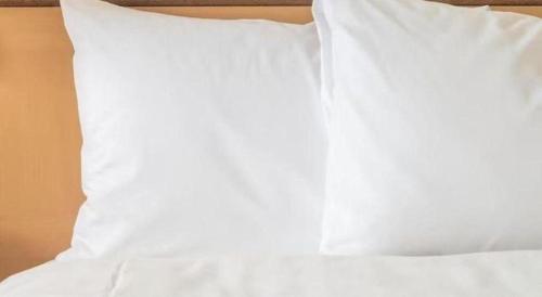 a white pillow sitting on top of a bed at Xana Hotelle Xi'an 2nd Fengcheng Road Municipal Library Metro Station in Xi'an