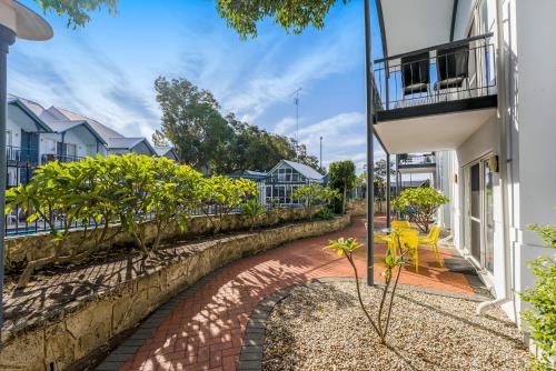 a brick walkway next to a house with a balcony at Mandurah Quay Resort in Mandurah