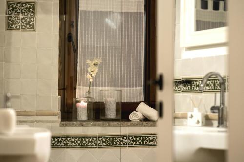 a bathroom with a sink and a vase with a flower at Donna Chiara in Nusco
