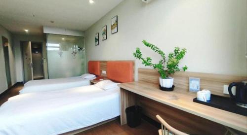 a bedroom with two beds and a potted plant at Shanghai Jiejia hotel in Shanghai