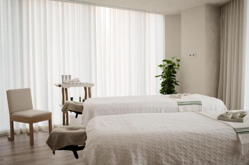 a hospital room with two beds and a chair at 1 Hotel Melbourne in Melbourne