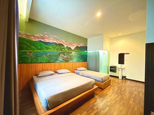 SintangにあるLadja Hotel Sintangのベッドが2つあり、壁に絵が飾られた寝室