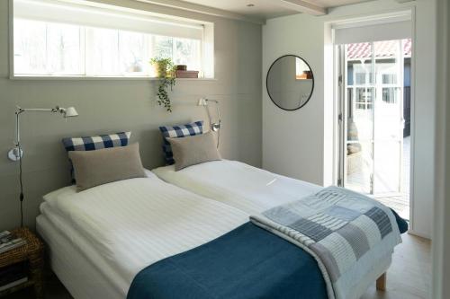 a bedroom with a bed and a mirror and a window at Modern Holiday Home Where Indoor And Outdoor Merge in Hals