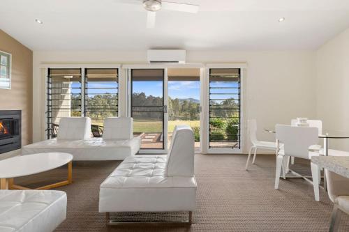 a living room with white furniture and a fireplace at H Boutique Hotel in Pokolbin