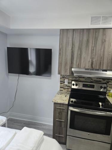 a kitchen with a stove and a flat screen tv at CDQI Hotel in Ottawa