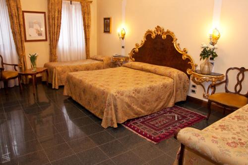 a hotel room with two beds and a couch at Residenza d'Epoca San Cassiano in Venice