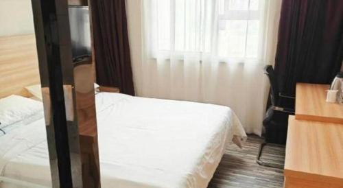 a hotel room with a bed and a window at City Comfort Inn Wuhan Guanggu Textile University in Wuhan