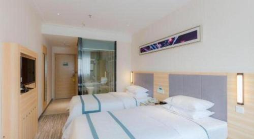 a hotel room with two beds and a television at City Comfort Inn Zhuhai Jinwan Hangkong Xincheng in Zhuhai