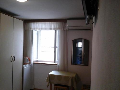 um quarto com uma janela, uma mesa e um espelho em Apartments Seka Korčula em Korčula