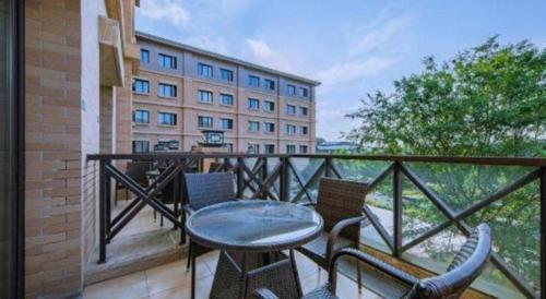 a balcony with a table and chairs and a building at Deefly Yinrun Town Hotel in Deqing