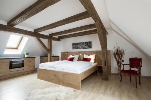 ein Schlafzimmer mit einem Bett und einem roten Stuhl in der Unterkunft Fischhof Beer in Mitterteich