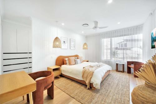 a bedroom with a bed and a table and a desk at Cinema Pool Pets 4b2b Bargara Headlands in Pemberton