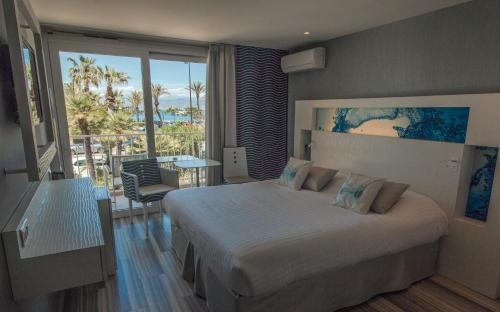 a bedroom with a bed and a view of the ocean at Hôtel Josse in Antibes