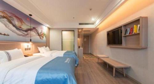 a hotel room with a large bed and a tv at Han Hotel Meisu Xi'an Longshouyuan Shenglong Plaza in Xi'an