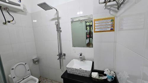 a bathroom with a toilet and a sink and a mirror at Vi Hostel-Motels-Hotel in Vũ Lâm