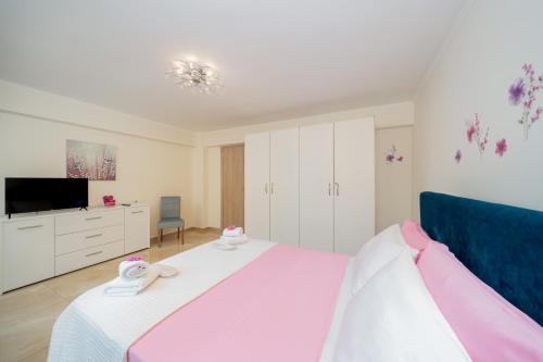 a bedroom with a bed with pink and white sheets at Melograno in Markopoulo