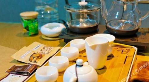 a table with white cups and bowls on it at E-Cheng Hotel Shenyang North Railway Station in Shenyang