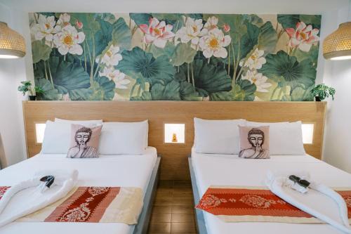 two beds in a room with a mural at Sitio Maupot Family Resort in Sampong