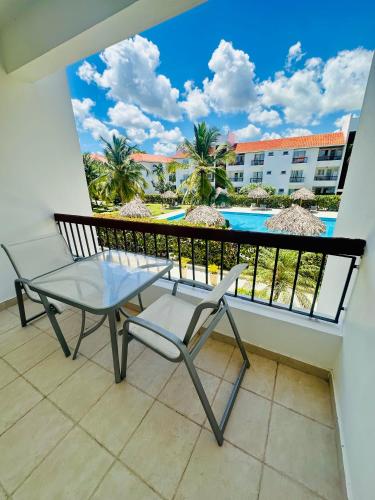 a balcony with a table and chairs and a swimming pool at La Esmeralda in Punta Cana