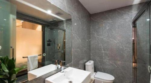 a bathroom with a sink and a toilet and a mirror at Green Tree Inn Express Fuzhou Three Lanes and Seven Alleys Nanmendou Metro Station in Fuzhou