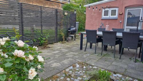 a patio with a table and chairs and a grill at Beautiful and romantic 2 bedroom villa on the island Aeroe in Søby
