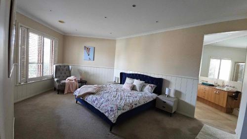 a bedroom with a bed and a chair and a mirror at Spacious Serene Luxury Retreat in Narre Warren South