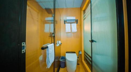 a bathroom with a toilet and a glass shower at Shell Hotel Wuhu Jiujiang District Daqiao Town Huashan Road in Wuhu