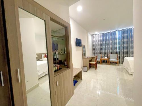 a hallway with a room with a bed and a mirror at SÀI GÒN - BẠC LIÊU Hotel in Bạc Liêu