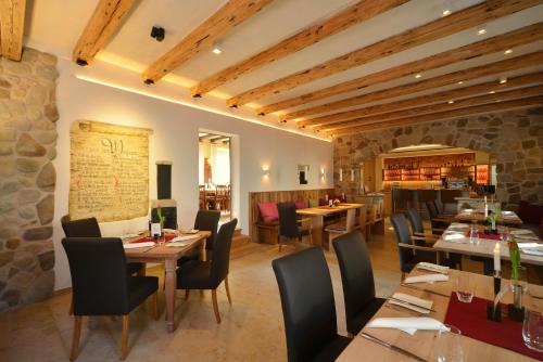 a restaurant with wooden tables and chairs and a stone wall at Das Crass in Nieder-Olm
